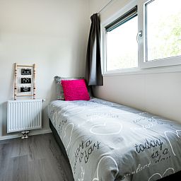 Gemuetliches Schlafzimmer im Modul 5-Personen-Ferienhaus in Berkhout, Nordholland, mit bequemen Betten und Tageslicht.