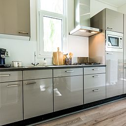 Gemuetliches Wohnzimmer des Ferienhauses "Module 5 Personen" in Berkhout, Nordholland, mit moderner Einrichtung und viel Tageslicht.