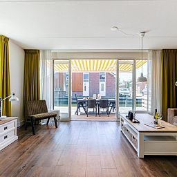 Spacious living room of Apartment Assum I in Uitgeest, North Holland, with a view of the terrace and modern furnishings for a relaxing stay.