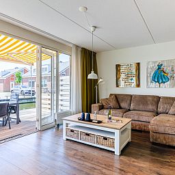 Cozy living room of Apartment Assum I in Uitgeest, North Holland, with comfortable seating area and view of the sunny terrace.