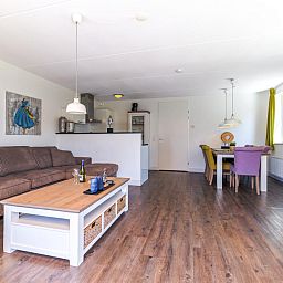 Cozy living room of Apartment Assum I in Uitgeest, North Holland, with comfortable seating area and modern kitchen.