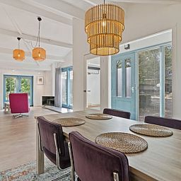 Stijlvolle eetkamer in Vakantiehuis in Heiloo, Noord-Holland, met moderne inrichting en uitzicht op de groene omgeving.
