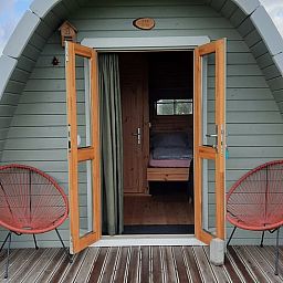 Openstaande deuren van Huisje in Zuid-Scharwoude, een vakantiehuis in Noord-Holland, met uitnodigend interieur.