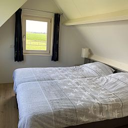 Garten des NH539 Ferienhauses in Spanbroek, Nordholland mit Gruenpflanzen und Zaun