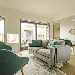 Stijlvolle woonkamer in 4-persoons Trompenburgh vakantiehuis, Loosdrecht, Noord-Holland, met veel lichtinval en comfort.