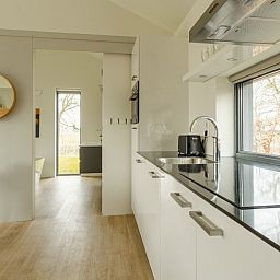 Moderne keuken in 4-persoons Trompenburgh vakantiehuis, Loosdrecht, Noord-Holland, met uitzicht op de groene omgeving.