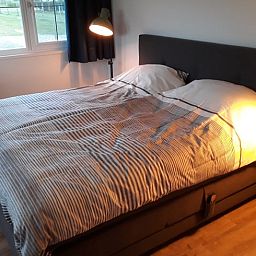 Gemuetliches Schlafzimmer im Ferienhaus in Nieuw Vennep, Ferienhaus in Nordholland mit bequemem Doppelbett und Blick auf den Garten.