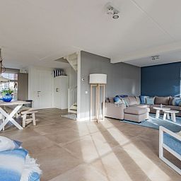 Stijlvolle woonkamer in Europarcs Poort van Amsterdam vakantiehuis, Uitdam, met moderne inrichting en veel natuurlijk licht.