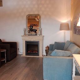 Cozy living room of Holiday Home in Weesp, Amsterdam eo, North Holland, with comfortable sofas and cozy fireplace.