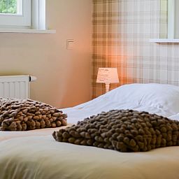 Komfortables Schlafzimmer im Cottage in Mander, Mander, Twente, mit gemuetlichen Betten und sanfter Beleuchtung.