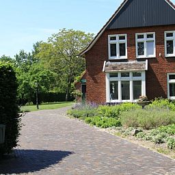 Einfahrt zum Ferienhaus in Mander, Twente, Overijssel, mit malerischem Garten und rustikaler Backsteinfassade.