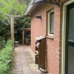 Seitenweg zum Eingang von Huisje in Nutter, Ferienhaus in Nutter, Twente, mit gruener Umgebung.
