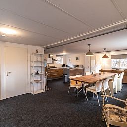 Gemuetlicher Innenbereich von Huisje in Den Ham, einem Ferienhaus in Twente, Overijssel, mit einer geraeumigen Kueche und einem Esstisch aus Holz.