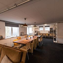 Gemuetliches Wohnzimmer in Cottage in Den Ham, Ferienhaus in Twente, Overijssel, mit geraeumiger Sitzecke und grossem Esstisch fuer einen entspannten Aufenthalt.