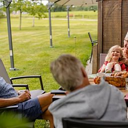 Geniessen Sie einen entspannenden Moment auf der Terrasse des Ferienhauses in Den Ham, Twente, umgeben von gruener Natur und Ruhe.