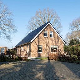 Vooraanzicht van Vakantiehuisje in Den Ham, Twente, met ruime oprit en omringende natuur.