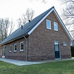 Achterzijde van Vakantiehuisje in Den Ham, Twente, met groene omgeving en moderne architectuur.