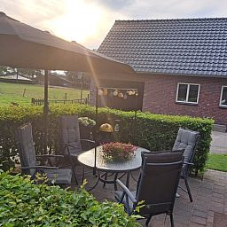 Zonnig terras bij Huisje in Den Ham, vakantiehuis in Den Ham, Twente, met comfortabele zitplaatsen.
