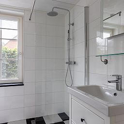 Inkomhal van vakantiehuis OV404 in Den Ham, Twente met moderne trap en deur naar de tuin.