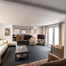 Gezellige woonkamer van Vakantiehuis in Den Ham, Twente, Overijssel met comfortabele zithoek en ruime eethoek voor een ontspannen verblijf.