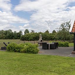 Geniessen Sie die Ruhe und den Frieden im Assenhoekje in Den Ham, Twente. Entspannen Sie sich auf der Terrasse dieses Ferienhauses mit Blick auf gruene Felder.