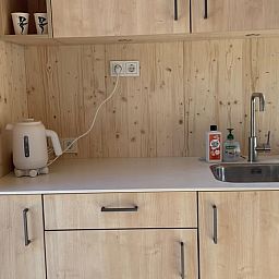 Moderne kitchenette in Vakantiehuisje in de Lutte, Twente, met houten afwerking.