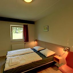 Slaapkamer in vakantiehuisje in Hezingen met tweepersoonsbed, gelegen in Twente, Overijssel.