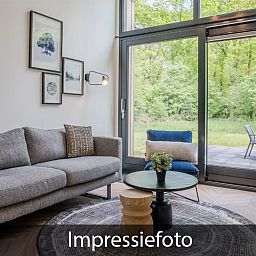 Comfortabele zithoek in Vrijstaande woning in Beuningen, vakantiehuis in Twente, met grote ramen.