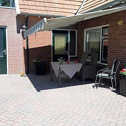 Geniet van de zonnige patio bij Huisje in Beuningen, een vakantiehuis in Twente, Overijssel, met comfortabele zitgelegenheid.