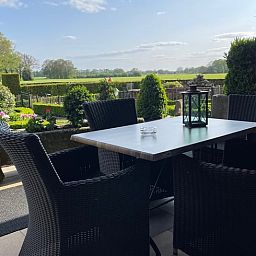 Terras met zitje bij Vakantiehuisje in Vasse, Twente, Overijssel, omgeven door natuur.