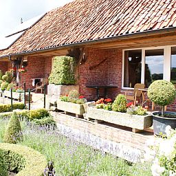 Charmante gevel van Vakantiehuisje in Vasse, Twente, Overijssel met bloementuin.