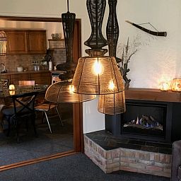 Esszimmer und Wohnzimmer in Cottage in Weerselo, Ferienhaus in Twente, Overijssel mit stimmungsvoller Beleuchtung.