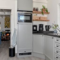 Gezellige woonkamer van Vakantiehuisje in Reutum, Twente met open haard en comfortabele zitruimte.