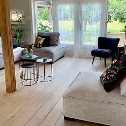 Stijlvolle woonkamer in Vakantiehuis in Reutum, Twente, Overijssel met grote ramen en veel lichtinval.