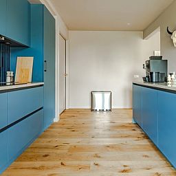Ruime keuken in Vakantiehuisje in Rijssen, Twente, Overijssel met moderne apparatuur en blauwe kasten.
