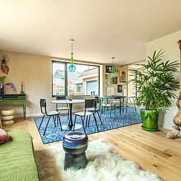 Gezellige woonkamer in Huisje in Rijssen, vakantiehuis in Twente, Overijssel met kleurrijke inrichting en uitzicht op de groene natuur.