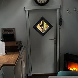 Knusse woonkamer met open haard in Huisje in Haaksbergen, vakantiehuis in Twente, Overijssel.