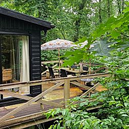 Huisje in Haaksbergen vakantiehuis met houten terras omringd door groene natuur in Twente, Overijssel. Perfect voor een ontspannen verblijf.