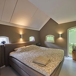 Charmantes Aeusseres der Design Lodge Twente in Haaksbergen, Overijssel, mit Backsteinfassade und ueppigem Garten.