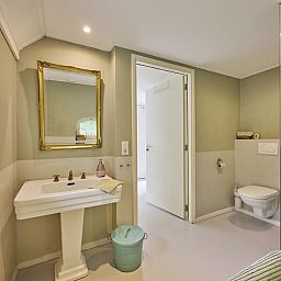 Modernes Wohnzimmer in der Design Lodge Twente, Haaksbergen, Overijssel, mit grossen Fenstern und stilvollen Moebeln.