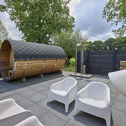 Zonnig terras bij The Green Getaway vakantiehuis in Haaksbergen, Twente met comfortabele ligstoelen.