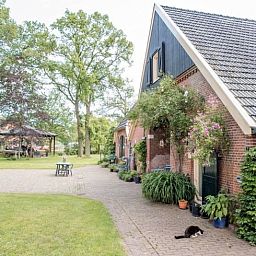 Vakantiehuisje in Diepenheim met groene tuinen en charmante bakstenen gevel.