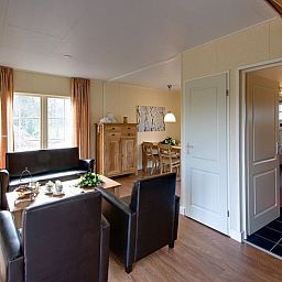 Gemuetliches Wohnzimmer im Ferienhaus in Enter, Twente, Overijssel, mit bequemer Sitz- und Essecke.