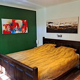 Bedroom in Cottage in Denekamp, vacation home in Twente, Overijssel, with colorful art on the wall.