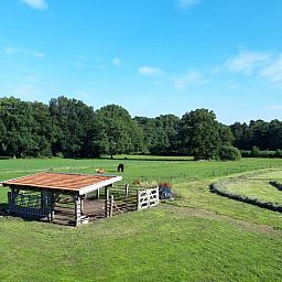 Geniessen Sie die laendliche Umgebung im Huisje in Losser, einem Ferienhaus in Twente, Overijssel, mit weitem Blick ueber gruene Felder.