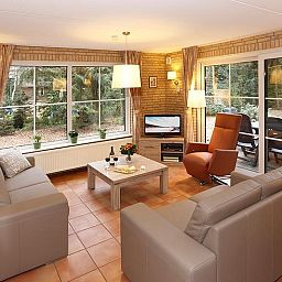 Cozy living room with terrace view in Boshuus Wellness vacation home, Twente.