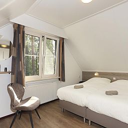 Schlafzimmer mit Doppelbett im Ferienhaus Boshuus Comfort Plus, Deurningen, Twente, Overijssel mit Blick auf die Natur.