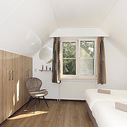 Helles Schlafzimmer im Boshuus Comfort Plus, Deurningen, Twente, Overijssel mit bequemen Betten und Blick auf die Natur.