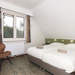 Comfortable bedroom in Boshuus Comfort Plus vacation home in Deurningen, Twente, overlooking the natural surroundings.