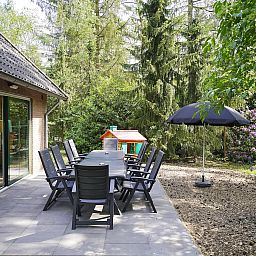 Terrasse mit Gartenmoebeln im Family House in Deurningen, umgeben von Natur.